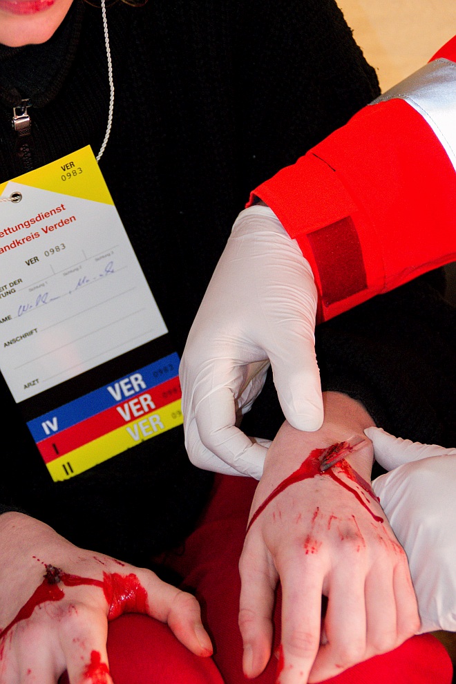 Aufbauübung für Behandlungsplatz 30 plus Mädchen mit einer Glasscherbe in der Hand