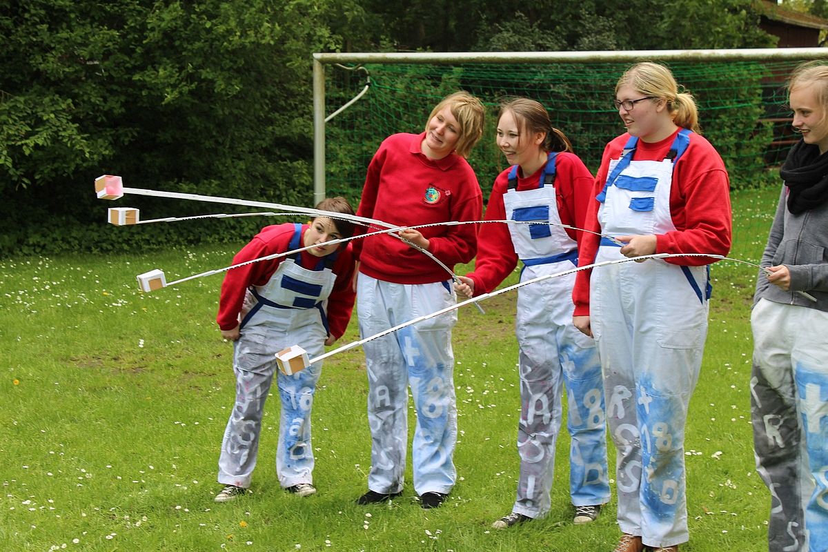 Fünf Mädchen übergeben einen Tischtennisball