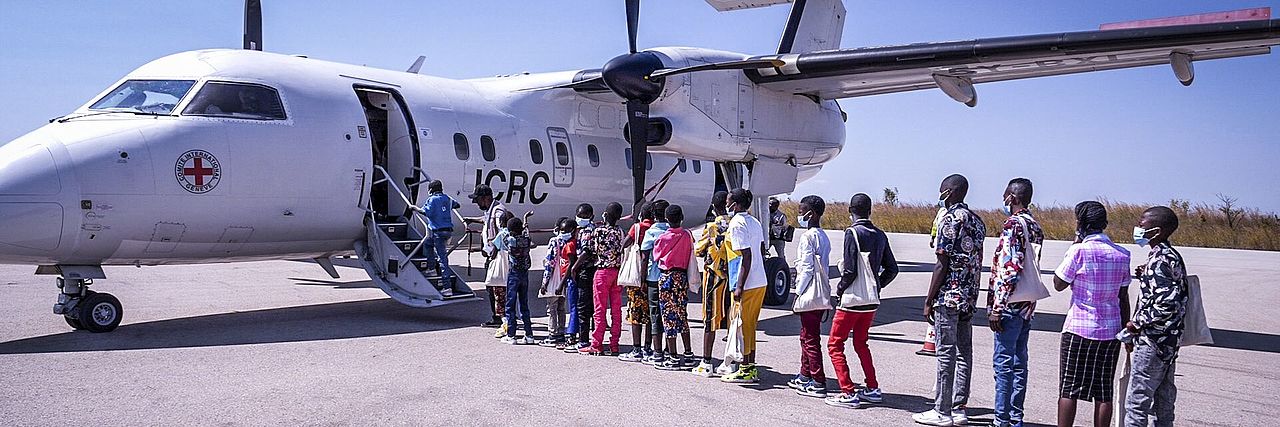 Kinder stehen vor einem IKRK-Flugzeug