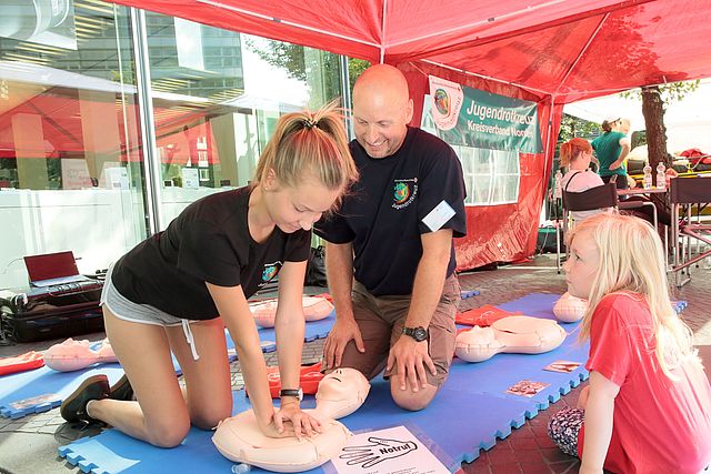 Mädchen lernt die Herzdruckmassage an einem Dummy