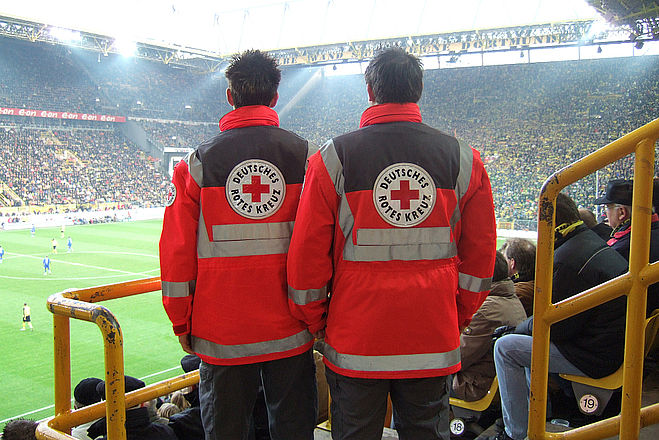 Rettungssanitäter des DRK in einem vollbesetzten Fussballstadion während eines Spiel der Weltmeisterschaft 2006